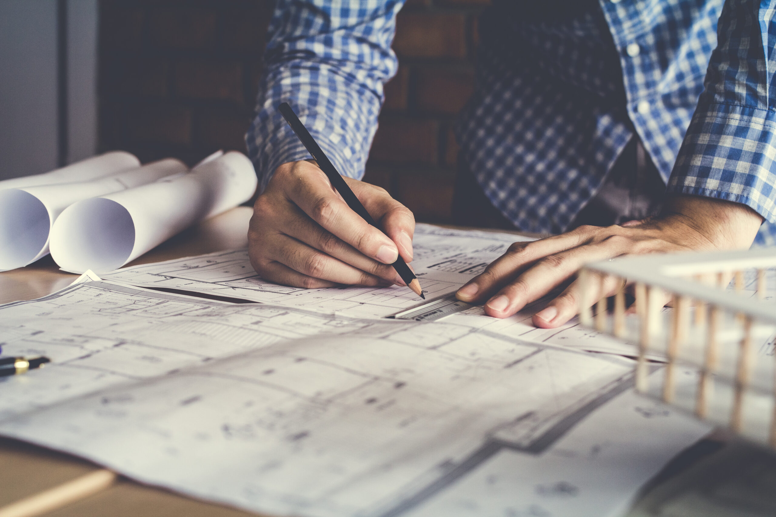Architects on the desk with a blueprint pen pointing on floor plan
